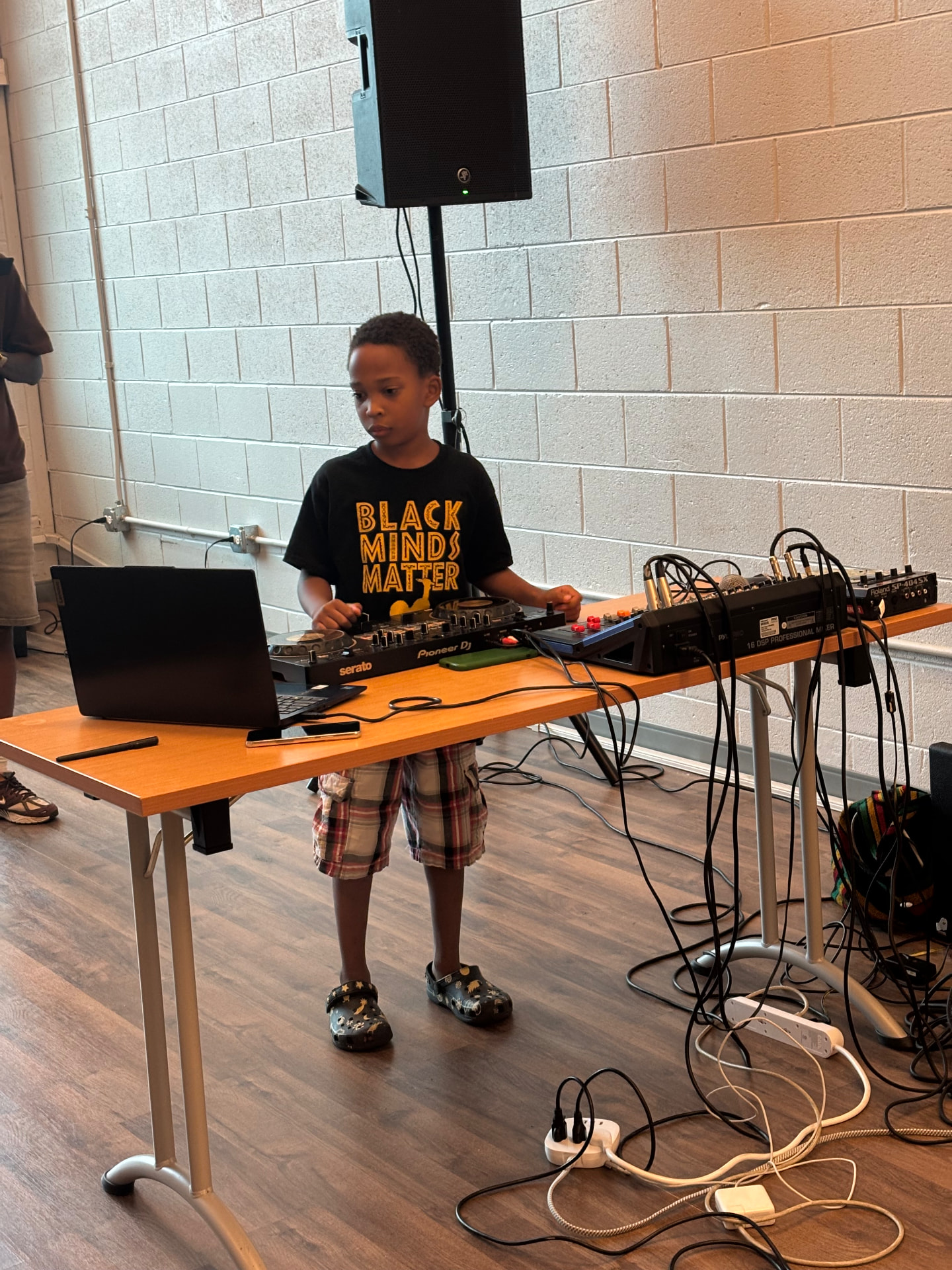 DJ King Kyro performing on a Pioneer DJ controller at a community event